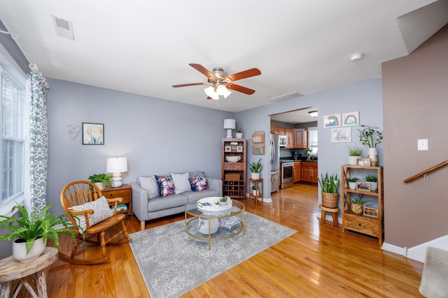 living room featuring ceiling fan and light wood-type flooring