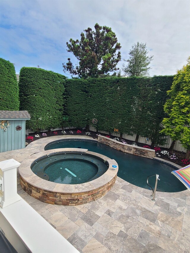 128 30th St, Avalon, NJ 08202 - view of swimming pool with an in-ground hot tub, a storage unit, a fenced backyard, and a patio area