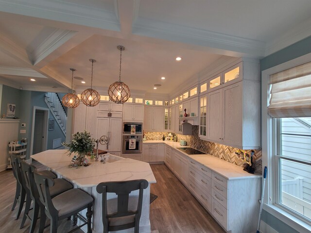128 30th St, Avalon, NJ 08202 - kitchen with black electric stovetop, crown molding, tasteful backsplash, a kitchen island with sink, and a kitchen bar