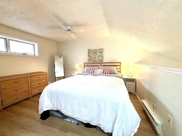 bedroom featuring vaulted ceiling, ceiling fan, a baseboard radiator, and a textured ceiling