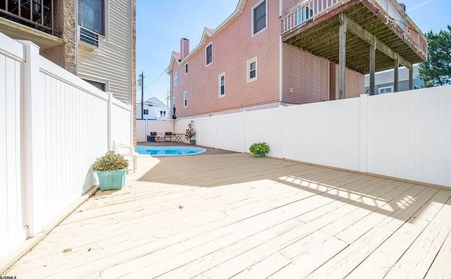 deck featuring a fenced in pool