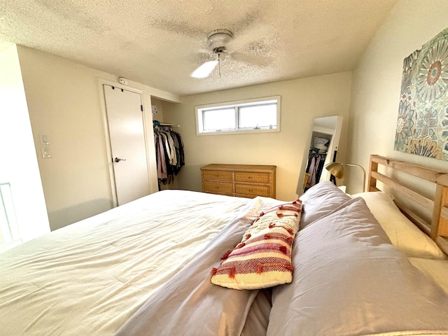 bedroom featuring ceiling fan, a spacious closet, a textured ceiling, and a closet