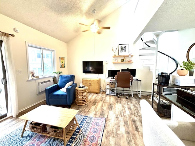 living room with a textured ceiling, a wall mounted AC, ceiling fan, light hardwood / wood-style flooring, and lofted ceiling