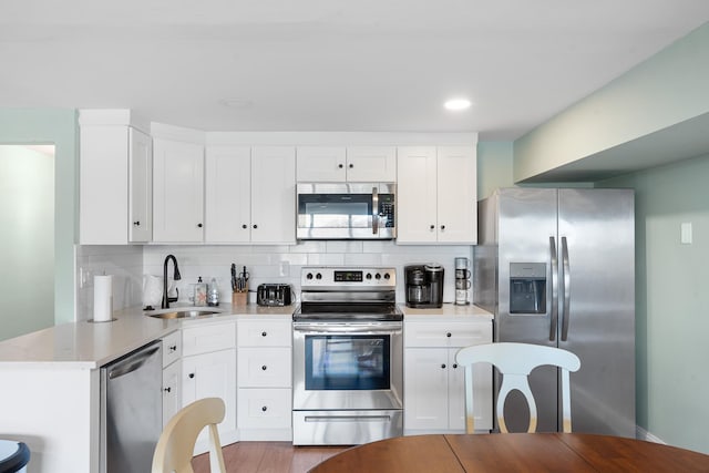3009 Dune Dr Unit 5, Avalon, NJ 08202 - kitchen with appliances with stainless steel finishes, decorative backsplash, white cabinets, wood finished floors, and recessed lighting