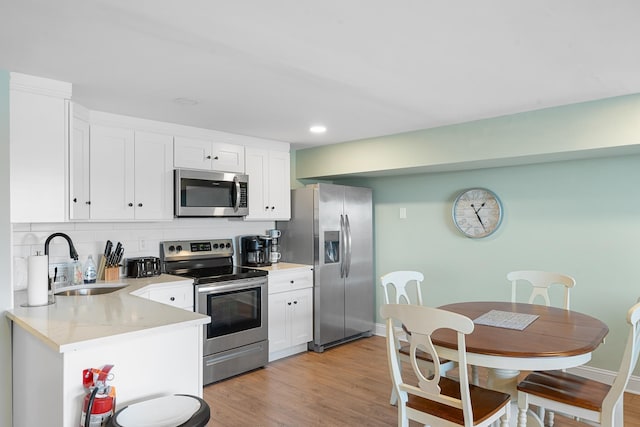 3009 Dune Dr Unit 5, Avalon, NJ 08202 - kitchen featuring appliances with stainless steel finishes, white cabinets, backsplash, light countertops, and light wood-style flooring