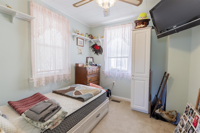 bedroom featuring visible vents, light carpet, and a ceiling fan