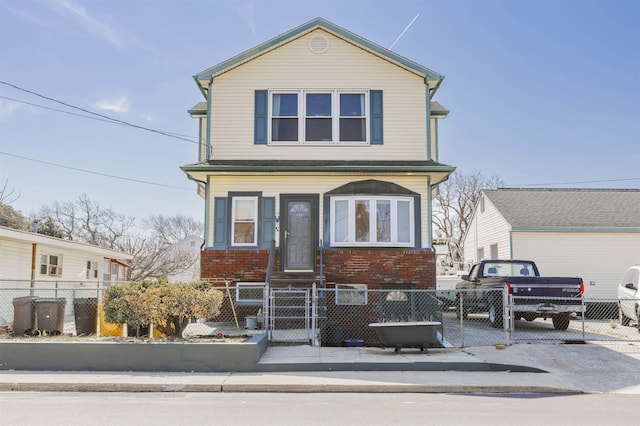 view of front of home with a gate, brick siding, and a fenced front yard