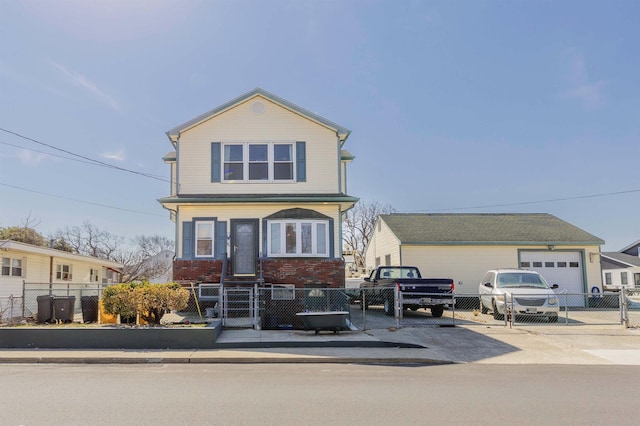 view of front facade featuring a fenced front yard, a gate, brick siding, and driveway