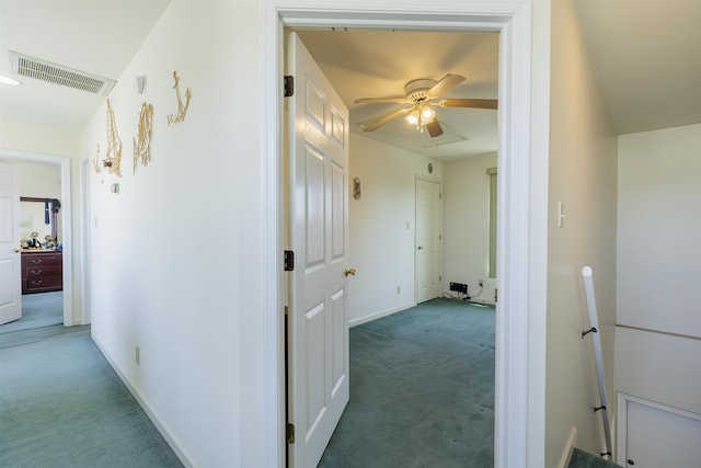 hall with carpet flooring, baseboards, and visible vents