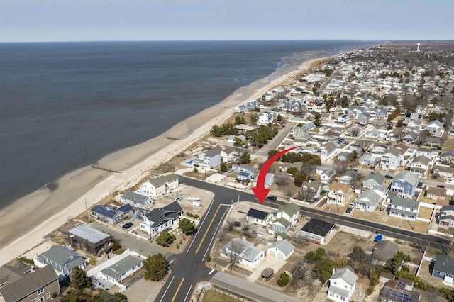 drone / aerial view featuring a residential view, a water view, and a view of the beach