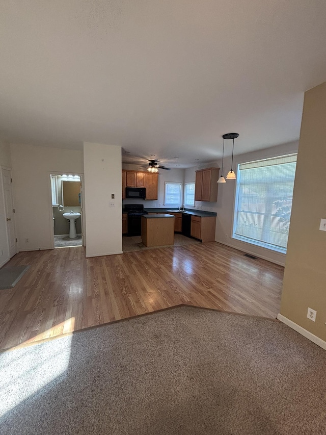 410 N 7th St Unit A, Rio Grande, NJ 08242 - kitchen featuring black appliances, open floor plan, dark countertops, brown cabinets, and light wood finished floors