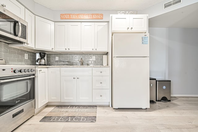5301 Atlantic Ave Unit J, Wildwood, NJ 08260 - kitchen with stainless steel appliances, white cabinetry, tasteful backsplash, and light wood-style floors