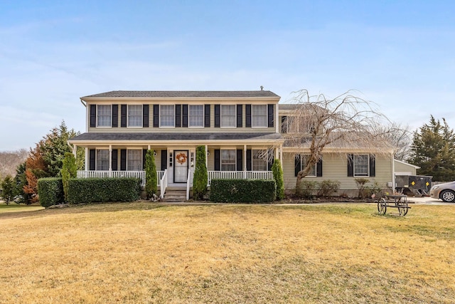 colonial-style house featuring a porch and a front yard