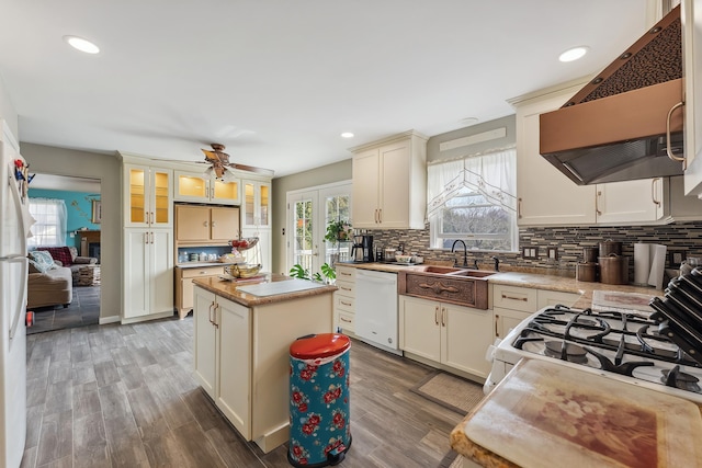 kitchen featuring white appliances, decorative backsplash, french doors, exhaust hood, and light wood-type flooring