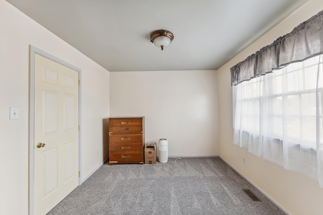 unfurnished room featuring visible vents, carpet flooring, and baseboards