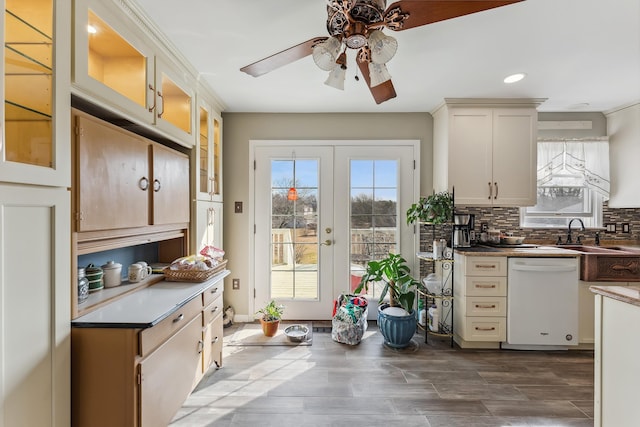 kitchen featuring a sink, backsplash, plenty of natural light, and white dishwasher