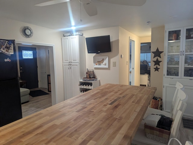 bedroom with black fridge, ceiling fan, and hardwood / wood-style flooring