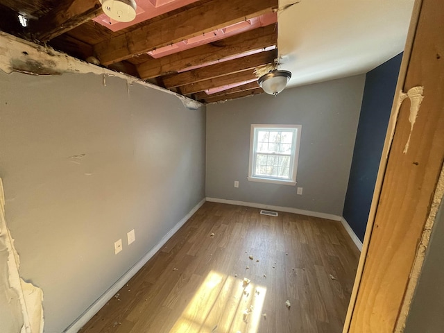 unfurnished room with hardwood / wood-style floors and vaulted ceiling