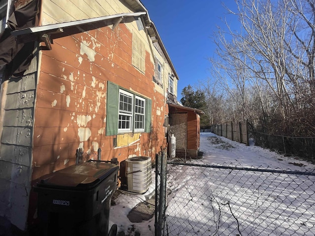 snow covered property featuring central air condition unit