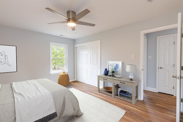 bedroom with hardwood / wood-style flooring, ceiling fan, and a closet