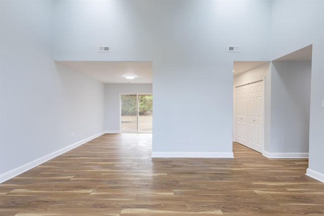 spare room with a high ceiling and hardwood / wood-style flooring