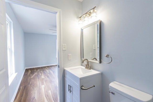 bathroom featuring ceiling fan, vanity, wood-type flooring, and toilet