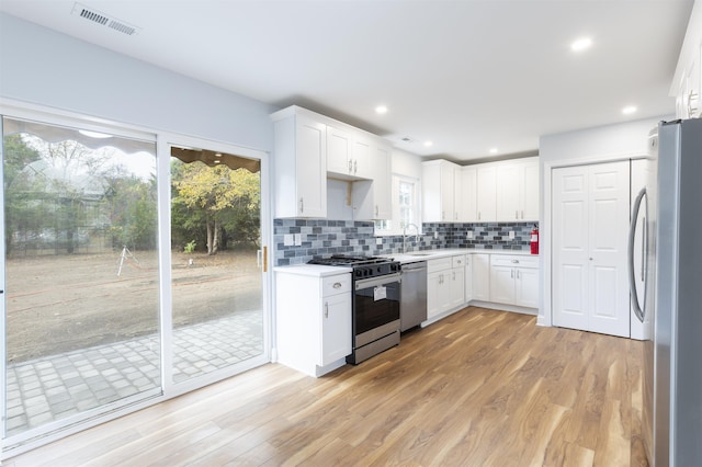 kitchen featuring light wood-type flooring, stainless steel appliances, white cabinetry, and sink