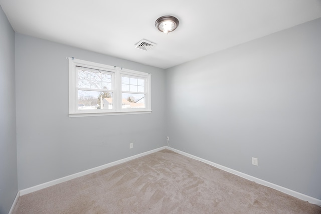 carpeted spare room with visible vents and baseboards