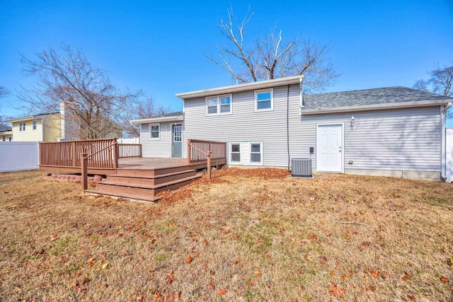 rear view of house with a deck, a yard, central AC, and fence