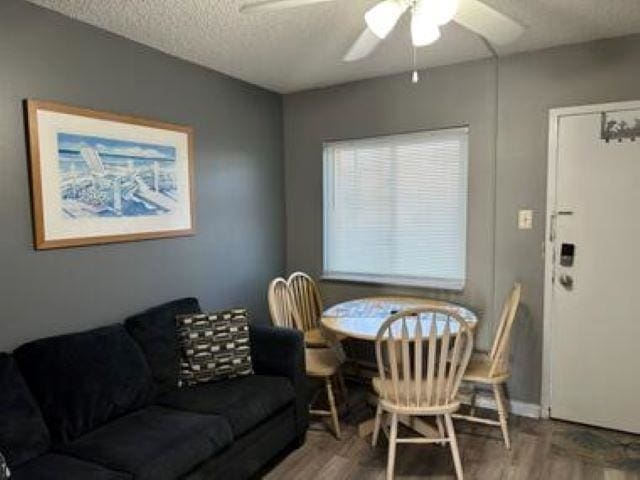 dining space featuring ceiling fan, hardwood / wood-style floors, and a textured ceiling