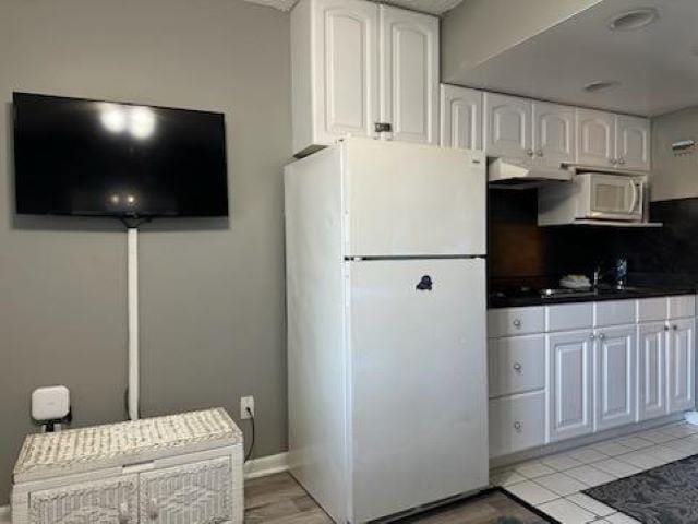 kitchen featuring decorative backsplash, white appliances, extractor fan, sink, and white cabinetry