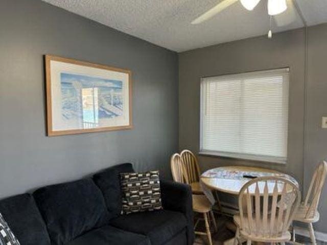 dining area featuring ceiling fan and a textured ceiling