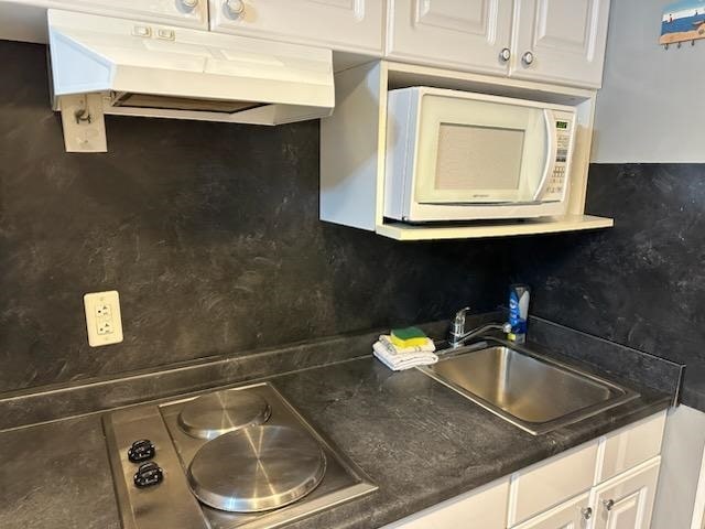 kitchen featuring decorative backsplash, white cabinetry, sink, and stainless steel cooktop