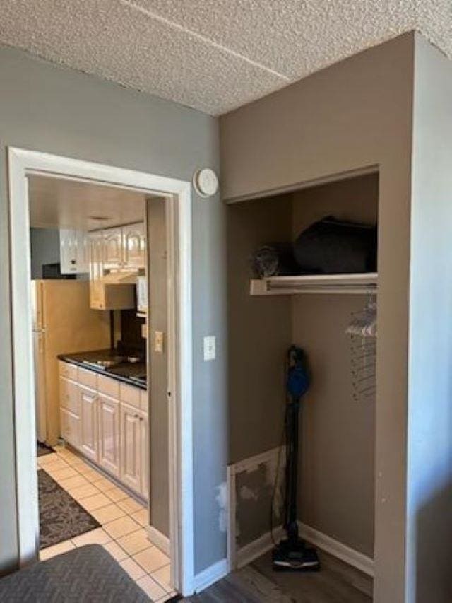 interior space featuring a textured ceiling and stainless steel refrigerator