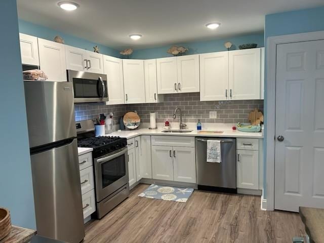 kitchen with stainless steel appliances, sink, and white cabinets