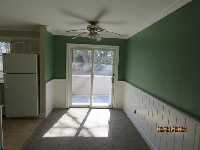 unfurnished dining area with a healthy amount of sunlight, ornamental molding, and wainscoting