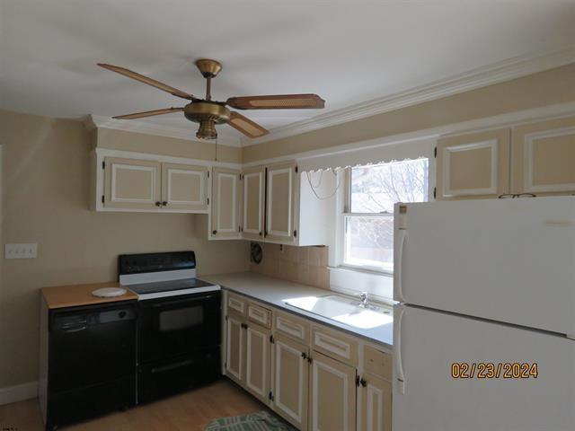 kitchen featuring ceiling fan, a sink, light countertops, ornamental molding, and black appliances