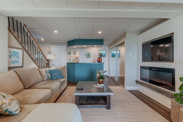 living room with hardwood / wood-style floors and a drop ceiling