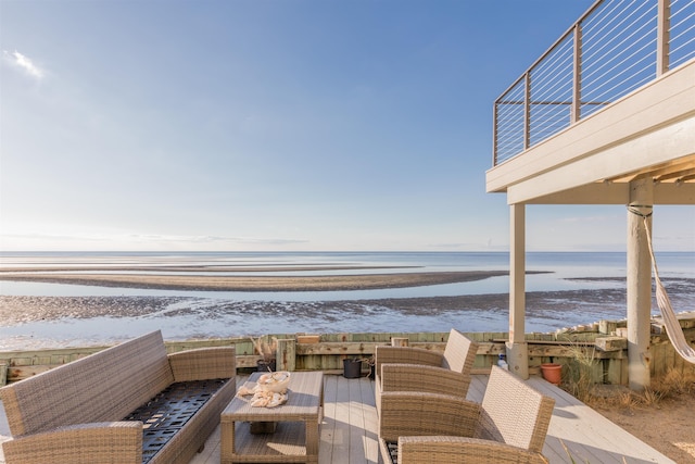 exterior space with an outdoor living space, a water view, and a beach view