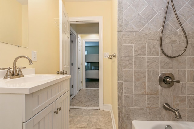 bathroom featuring tile patterned flooring, vanity, and tiled shower / bath