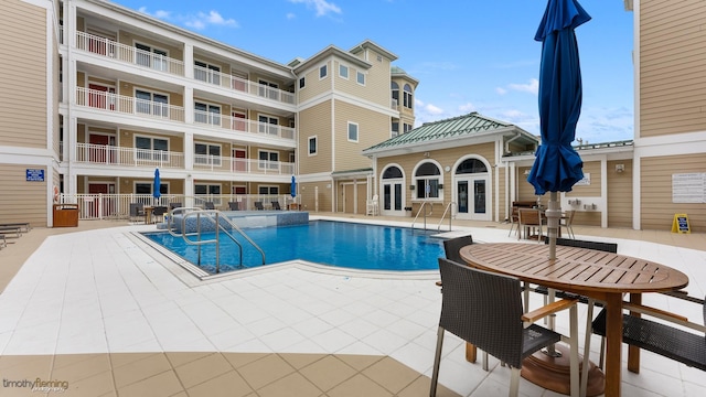 view of swimming pool with pool water feature and a patio