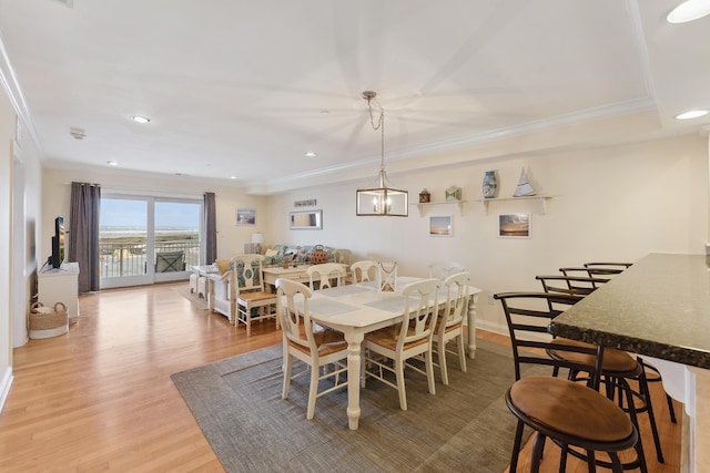 dining space featuring crown molding and wood-type flooring