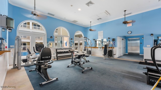 gym with crown molding and a high ceiling