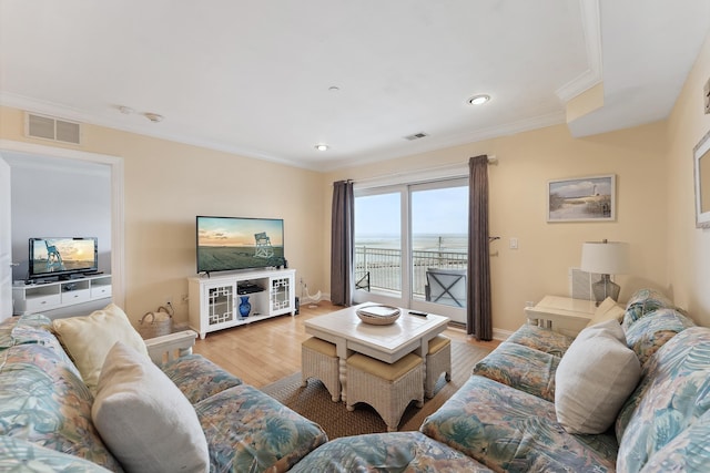 living room with crown molding and light hardwood / wood-style floors