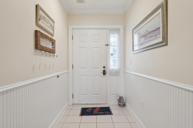 entryway with light tile patterned flooring and crown molding