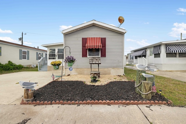 manufactured / mobile home with entry steps and concrete driveway