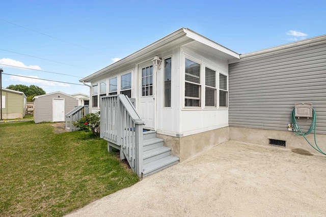 exterior space featuring a storage unit, an outdoor structure, a yard, and crawl space