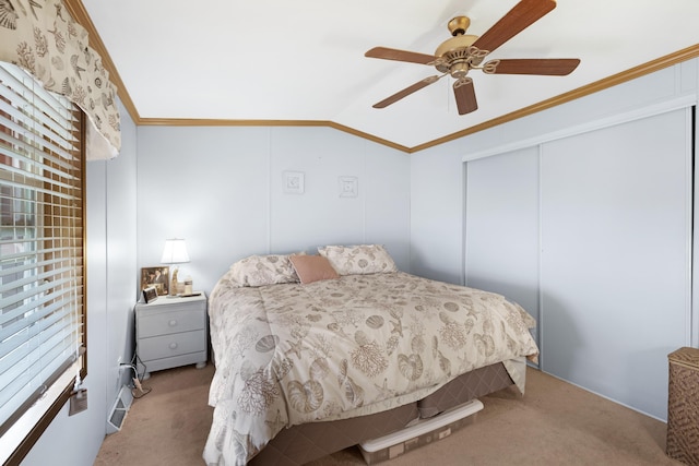 carpeted bedroom with vaulted ceiling, ornamental molding, a closet, and ceiling fan
