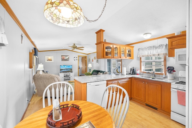 kitchen with light wood-style floors, ornamental molding, vaulted ceiling, and white appliances