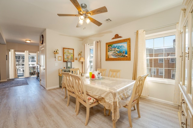 dining space featuring light wood-type flooring, visible vents, baseboards, and ceiling fan